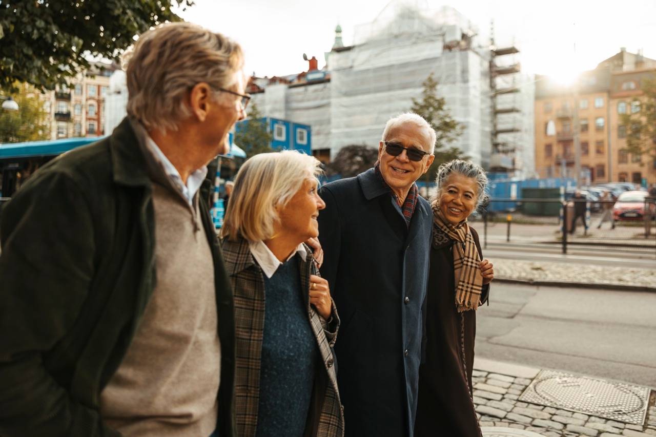 Två äldre par promenerar i stadsmiljö